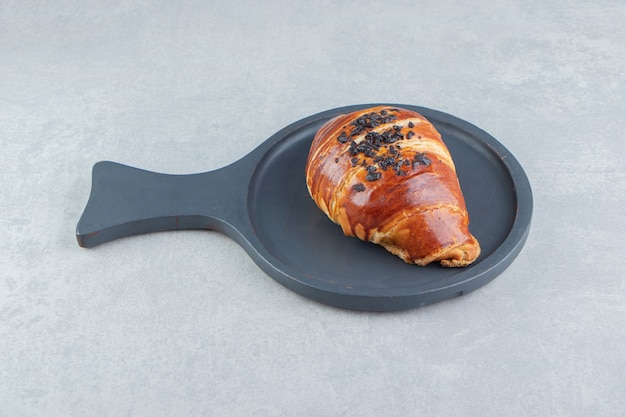 Free Photo fresh croissant decorated with drop chocolate on black board. 