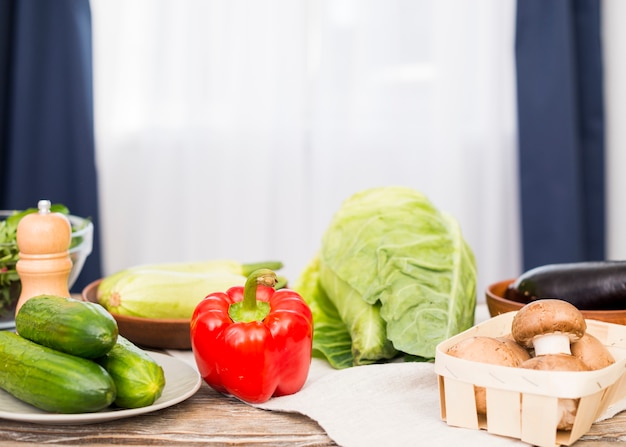 Fresh cucumber; bell pepper; mushroom; cabbage on desk