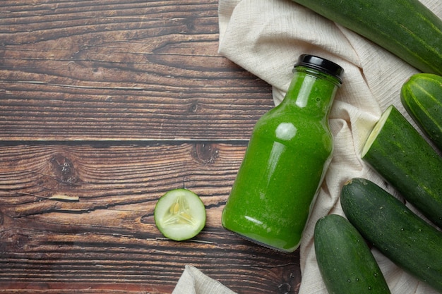 Fresh cucumber juice in a jar on dark wood background