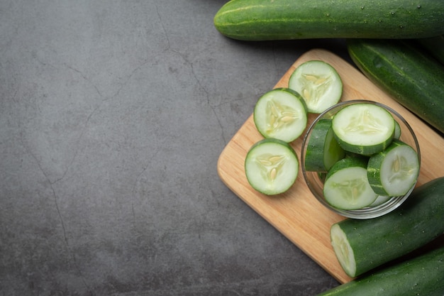 Fresh cucumbers sliced on dark background