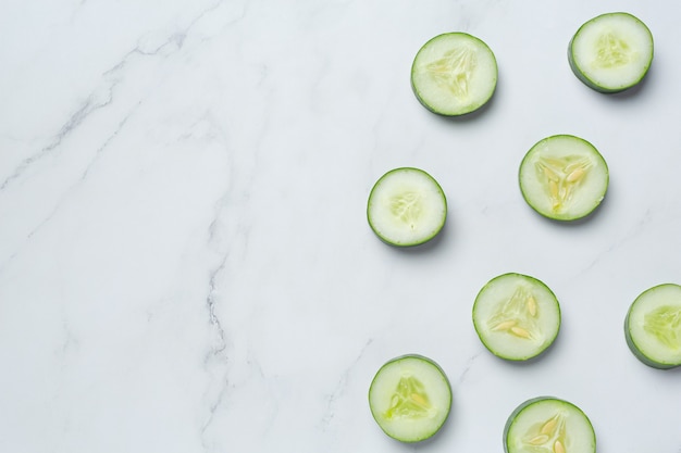 Fresh cucumbers sliced on marble background