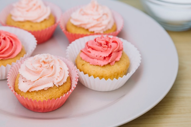 Fresh cupcake with rose buttercream icing on plate