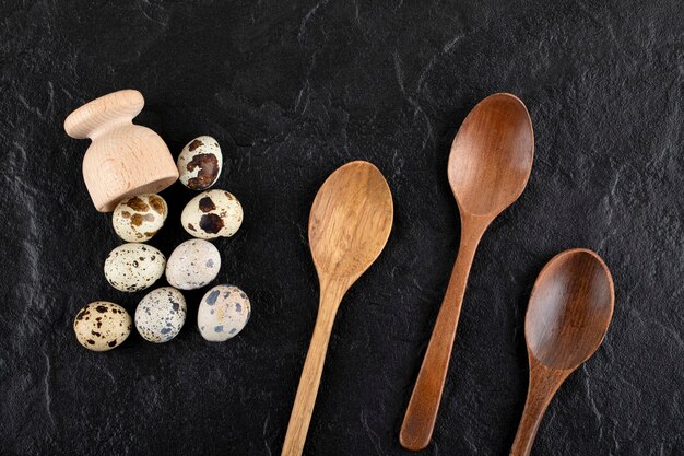 Fresh farm quail eggs out of wooden box with spoons. 