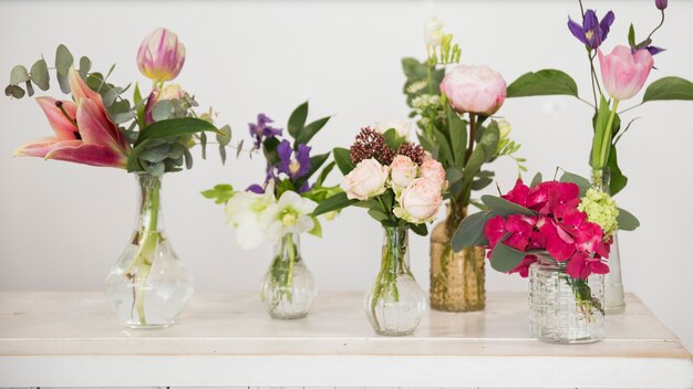 Fresh flower vases on the desk against white backdrop