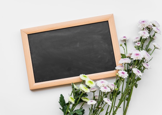 Fresh flowers on stems with chalkboard