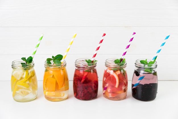 Free photo fresh fruit jugs with straws