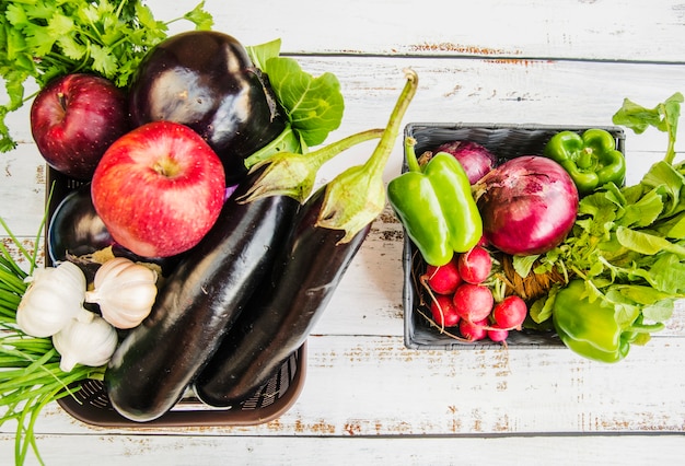 Free photo fresh fruits; and vegetables in plastic basket over wooden table