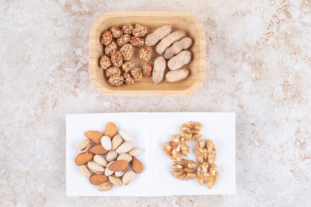 Fresh and glazed peanuts next to walnuts, almonds and pistachios 