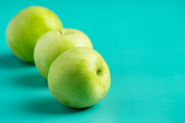 Fresh green apples put on light green background