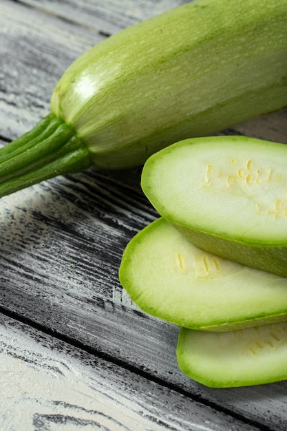 Fresh green marrow sliced on grey wooden desk