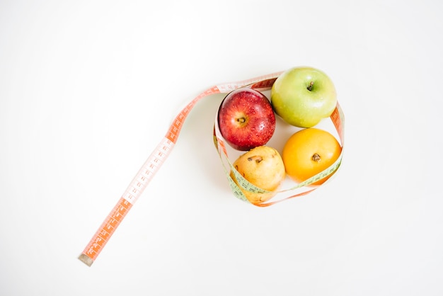 Free Photo fresh healthy fruits covered with measuring tape