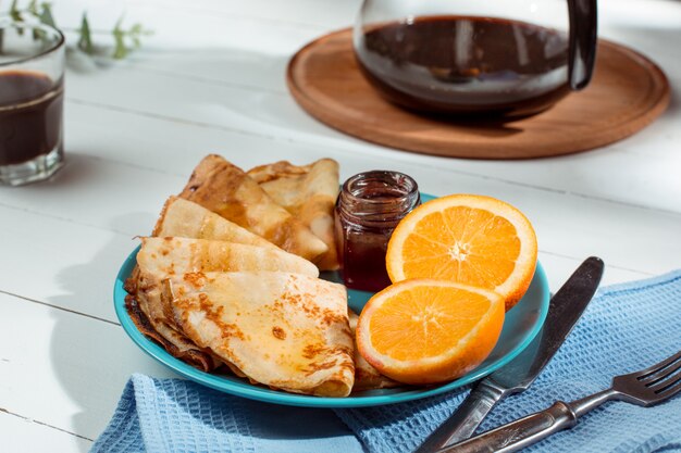 Fresh homemade french crepes made with eggs, milk and flour, filled with marmalade on a vintage plate