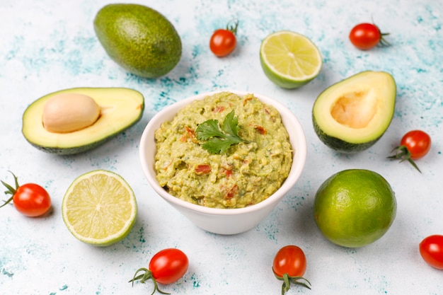 Fresh homemade hot guacamole sauce with ingredients, top view