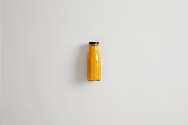 Free photo fresh homemade mango pineapple orange smoothie in glass bottle isolated on white background. balanced combination of carbs, fiber, protein and healthy fats. beverage that maintains calorie deficit