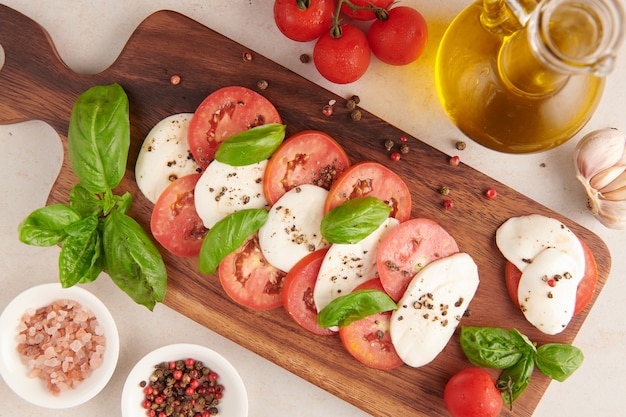 Free Photo fresh italian salad antipasto called caprese with buffalo mozzarella, sliced tomatoes and basil with olive oil. ingredients for vegetarian caprese salad. italian food. top view. rustic style.