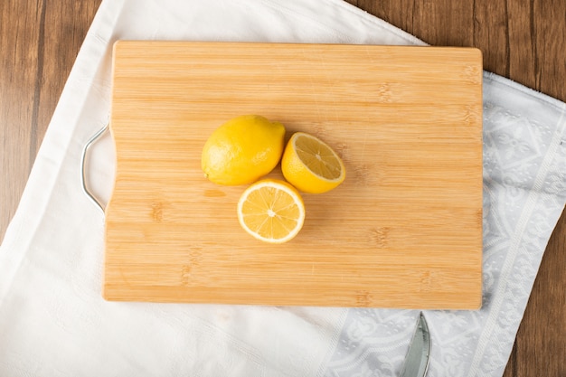 Fresh juicey lemons on a wooden board. top view