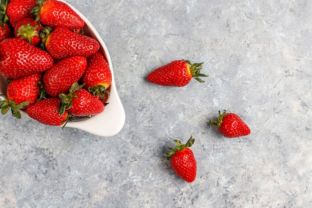 Fresh juicy strawberries on light wall,top view