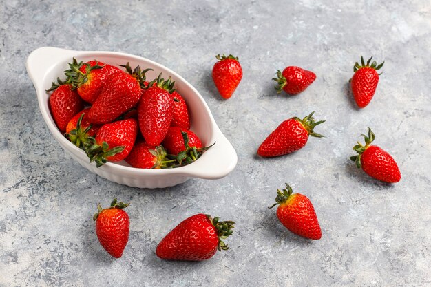 Fresh juicy strawberries on light wall,top view