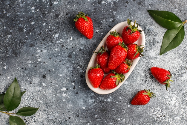 Free photo fresh juicy strawberries on light wall,top view