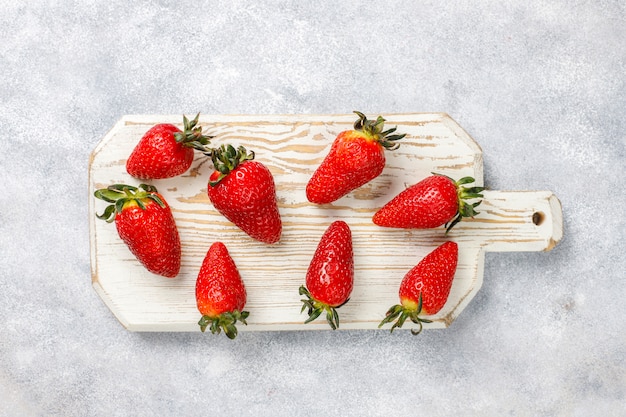 Free photo fresh juicy strawberries on light wall,top view