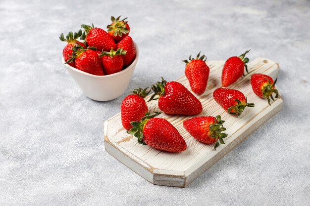 Fresh juicy strawberries on light wall,top view