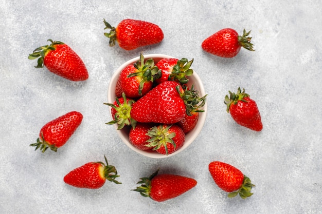 Fresh juicy strawberries on light wall,top view