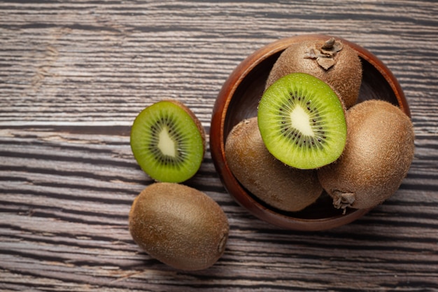 Fresh kiwi, cut into half, put on a wooden bowl