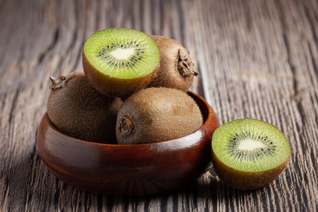 Fresh kiwi, cut into half, put on a wooden bowl