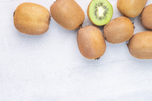 Fresh kiwi fruits, whole and sliced, on the marble.