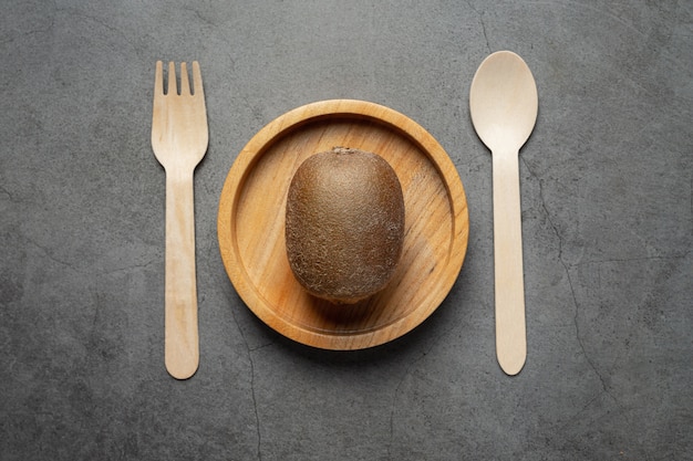 Fresh kiwi put on round wooden plate