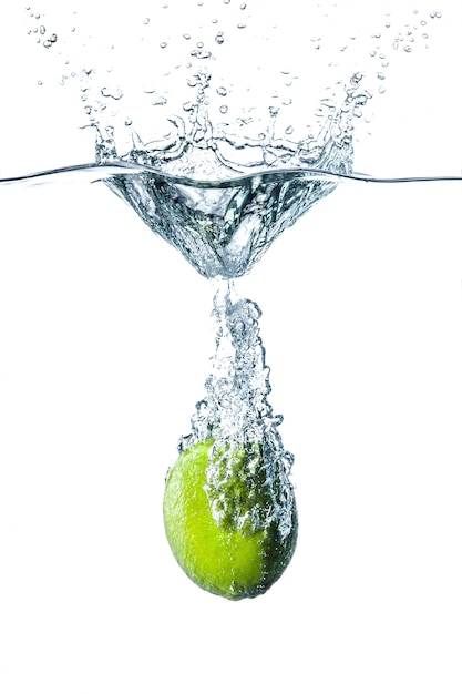 Fresh lime falling into water