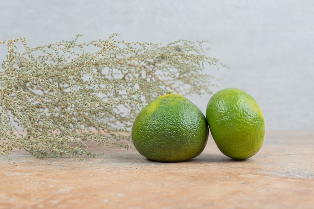 Fresh mandarines on marble background with grass.