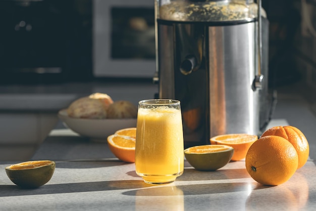 Free photo fresh orange juice in a glass close up on kitchen table