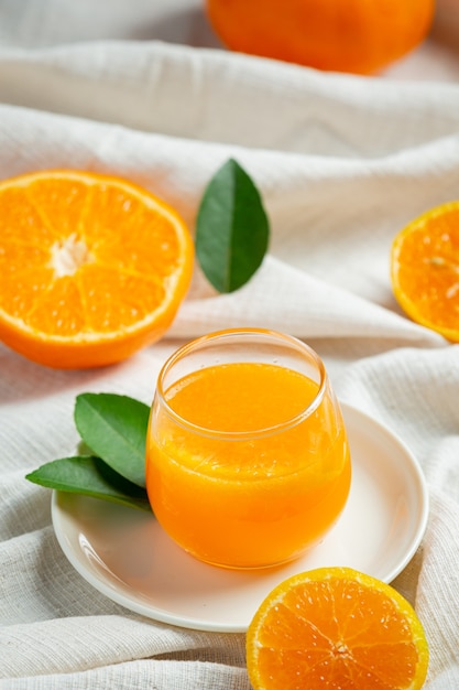 Fresh orange juice in the glass on marble background