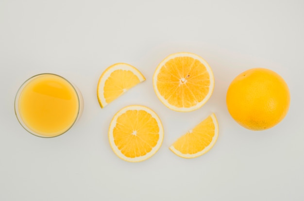 Fresh orange juice and slices on table