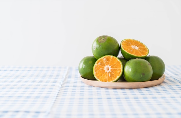 Free photo fresh orange on wood plate