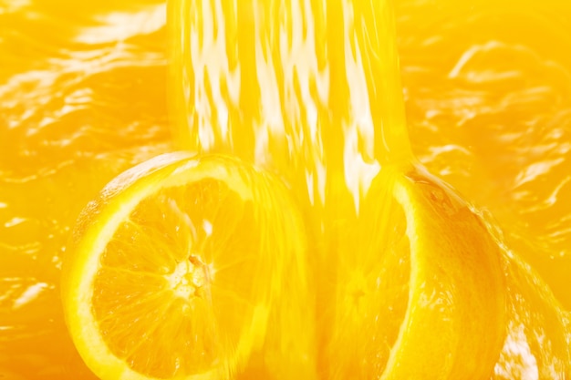 Fresh oranges falling in juice