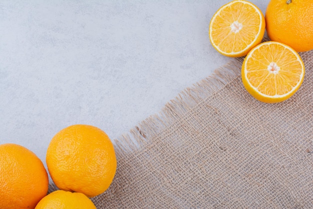 Fresh oranges lying on sackcloth on white background. High quality photo