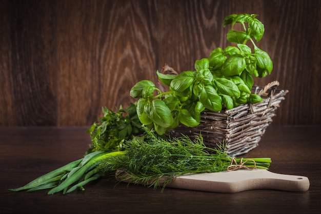 Fresh organic green herbs on wood