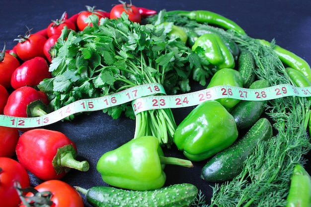 Fresh organic parsley, tomatoes, red peppers, green peppers, fennel, dill and cucumber with green centimeter top view, diet concept