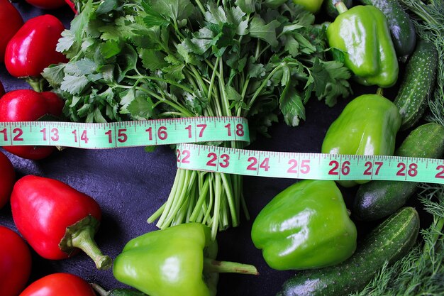 Fresh organic parsley, tomatoes, red peppers, green peppers, fennel, dill and cucumber with green centimeter top view, diet concept