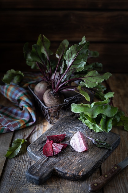 Free photo fresh organic red beets with leaves in a wicker basket on a wooden table. natural organic vegetables. autumn harvest. rustic