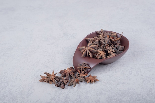 Free photo fresh organic star anise spice fruits on dark plate.