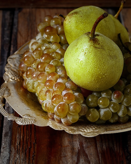 Free photo fresh pears and green grapes. autumn nature concept.