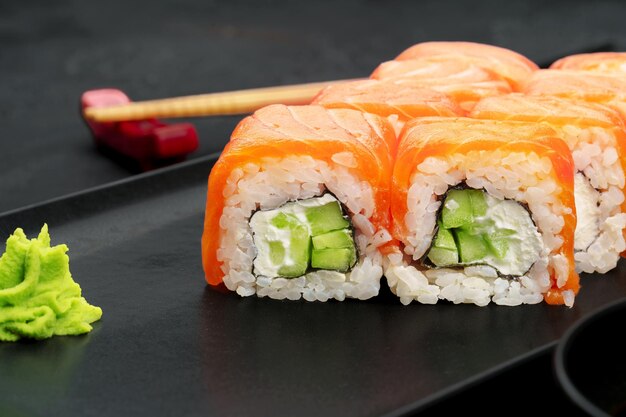 Fresh philadelphia sushi roll served on black plate