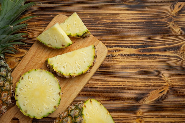 Free photo fresh pineapple on dark wooden surface