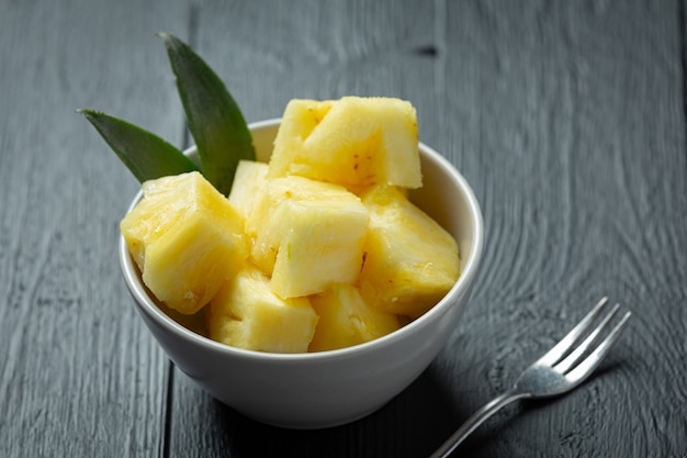 Fresh pineapple on dark wooden surface