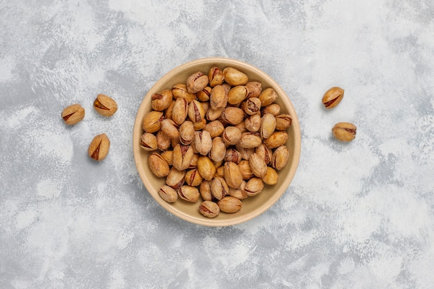 Fresh pistachios in ceramic plates.top view