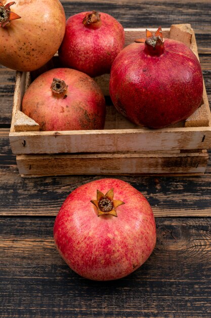 fresh pomegranate in basket top view on wooden table