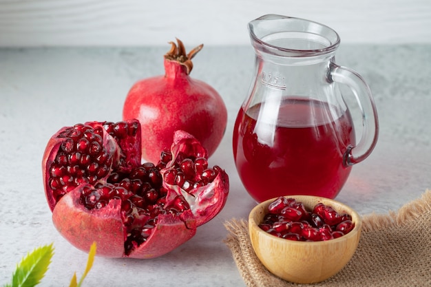 Fresh pomegranates with juice . Whole or sliced pomegranates on grey wall.